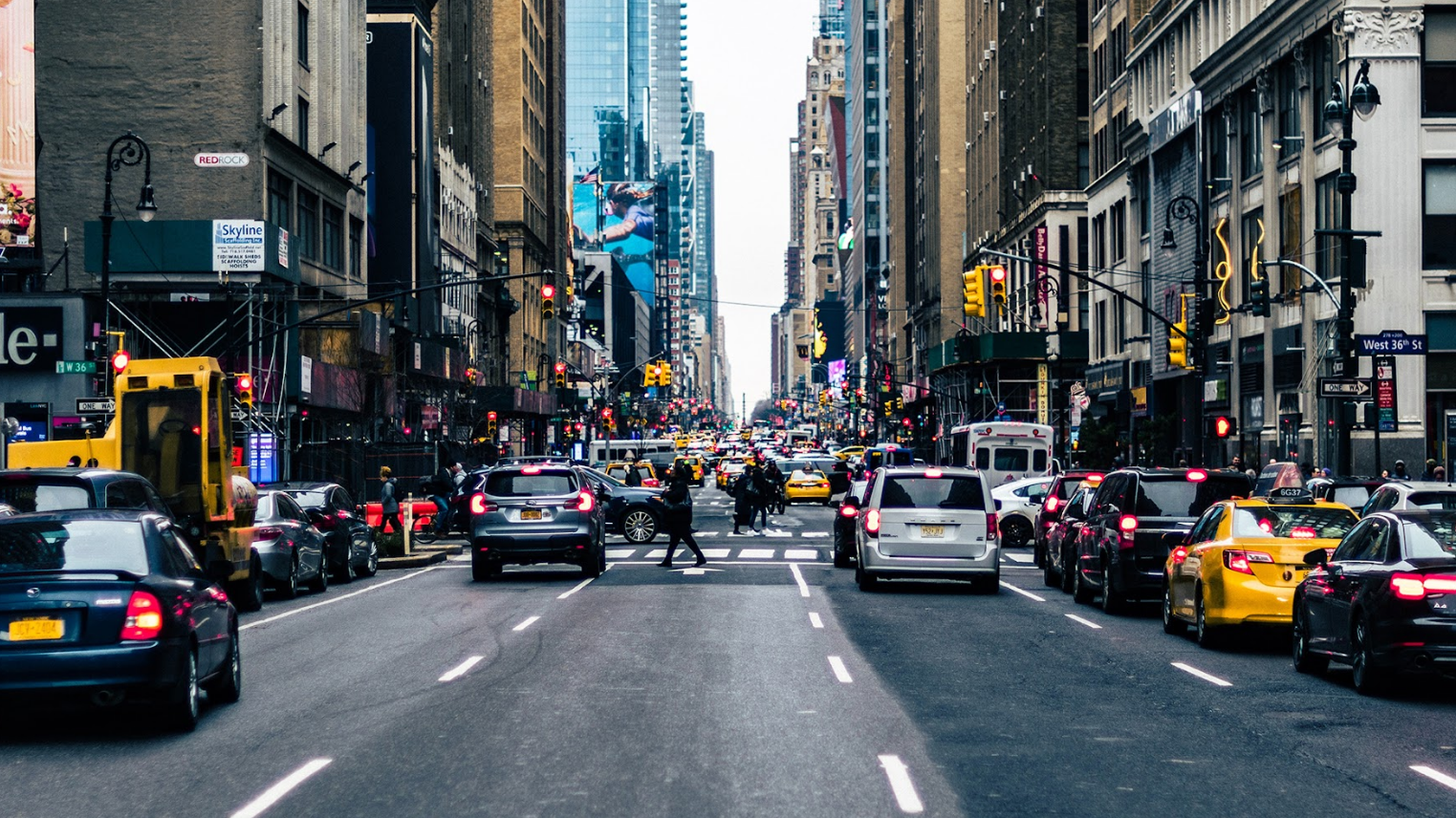 New York City street during a busy afternoon with cars parked along both sides of the road