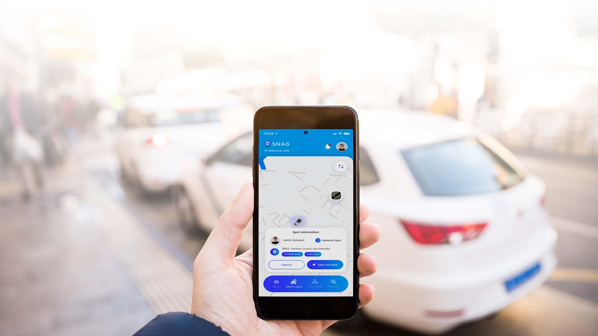 Hand holding a phone with SNAG parking app open, showing real-time parking data with cars in the background — visualizing smart parking in NYC.
