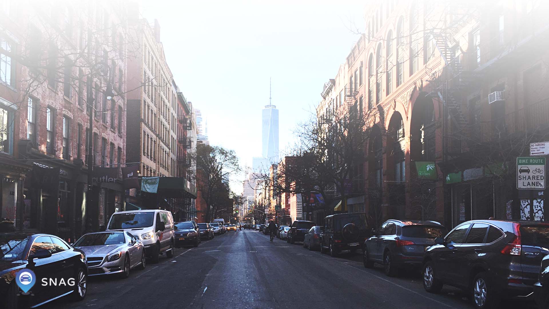 NYC street with parked cars lining both sides of the road, showcasing urban parking demand in Manhattan