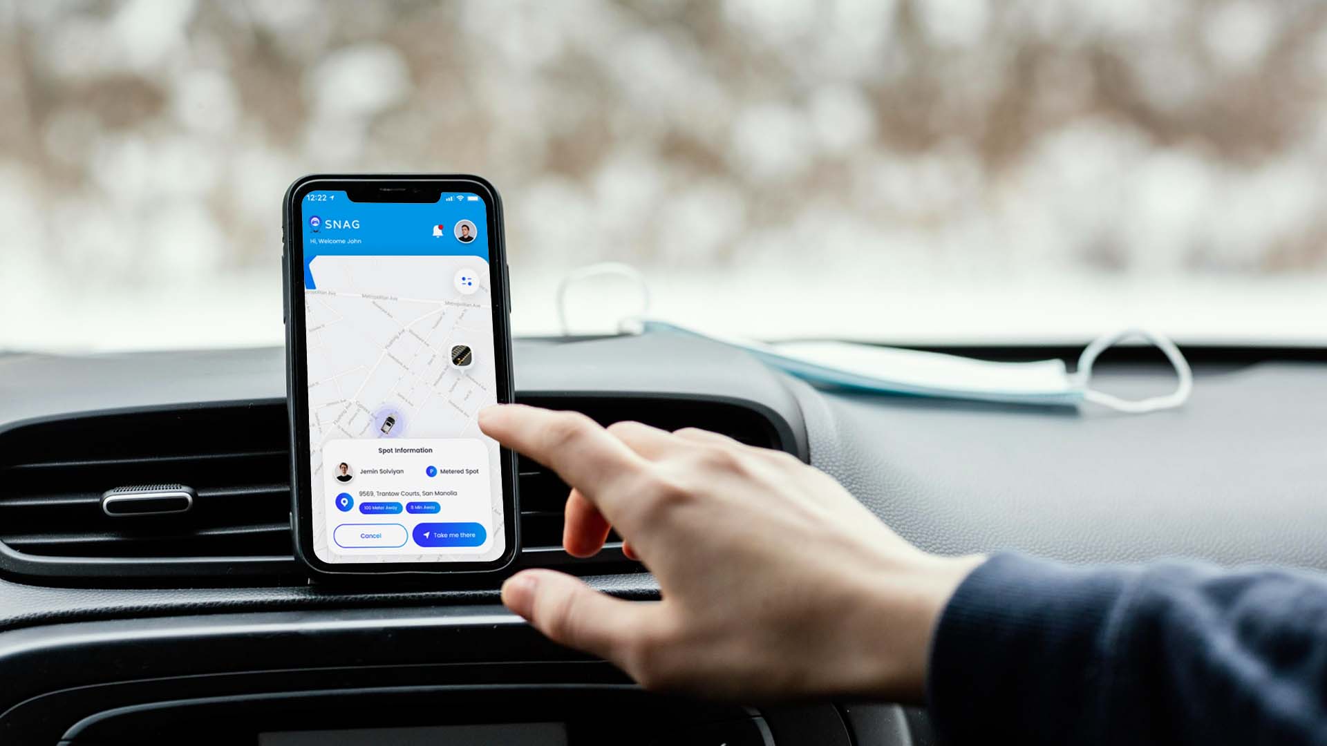 Driver using the SNAG app on a smartphone mounted on a car dashboard for real-time parking updates